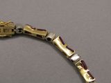 une image représentant un bracelet en or orné d'un motif rouge et blanc