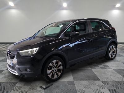 a black car is parked on a checkered floor in a garage