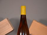 a bottle of wine sitting on a table next to a block of wood