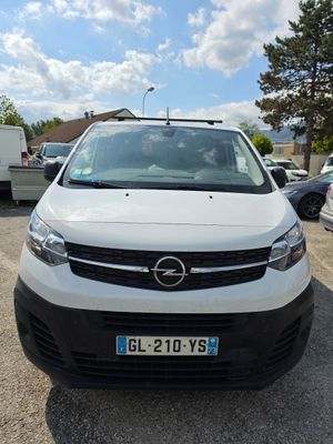 une camionnette blanche garée dans un parking avec d'autres voitures