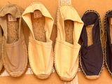 Plusieurs paires de chaussures sont alignées contre un mur