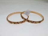 pair of gold tone bangles with engraved design