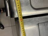 a measuring tape on the top of a stainless steel oven