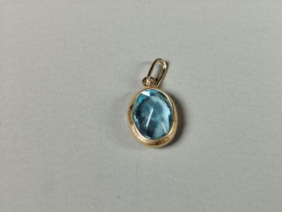 a small blue topaz stone pendant with a gold bail