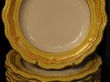 yellow and white plates stacked on top of each other on a table