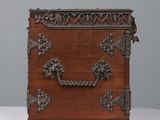 an old wooden box with ornate carvings and handles on a white surface