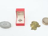 a small box with a ring in it next to a coin and a ring box