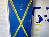 a blue door with yellow tape taped around it