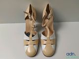 the woman ' s shoes are tan and white on a white surface
