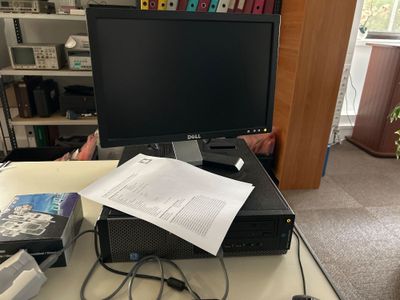 un écran d'ordinateur posé sur un bureau couvert de papiers