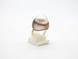 un gros plan d'une bague ornée d'une perle, posée sur un socle