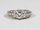 a close up of a diamond ring on a white surface