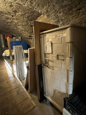 a refrigerator in the middle of a room with a lot of boxes