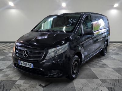 Le fourgon Mercedes est garé sur un sol à damier dans un garage.