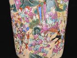 a vase with a painting on it sitting on a table