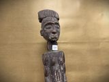 an old wooden statue of a woman with a hat on her head