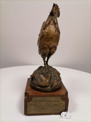 a bronze statue of a rooster on top of a plaque
