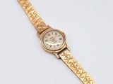 an image of a gold wrist watch on a white surface