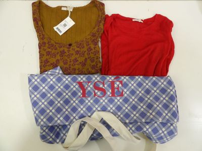 three shirts and a tote bag sitting on a table