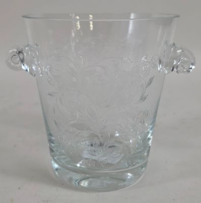 a clear glass vase with a handle on a table
