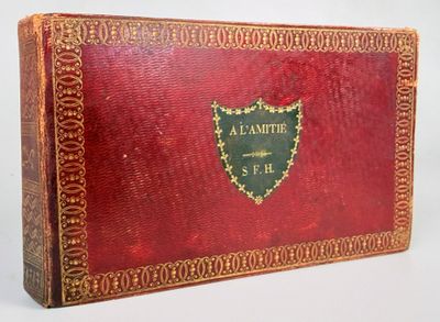 an old red book with gold trim and a shield on it