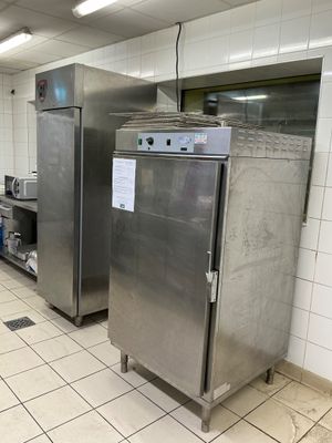 stainless steel refrigerators in a commercial kitchen with tiled flooring