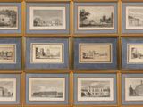 de nombreuses photos encadrées représentant des bâtiments, accrochées au mur