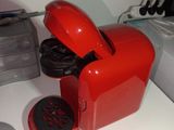 a red coffee maker sitting on a white counter