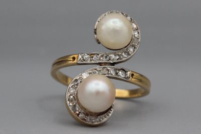 un gros plan sur une paire de bagues ornées de perles et de diamants