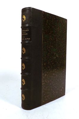 an old book sitting on top of a white table next to a white wall