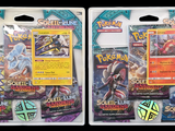 two packs of pokemon trading cards are shown on a black background