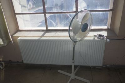 un ventilateur posé devant une fenêtre dans une pièce