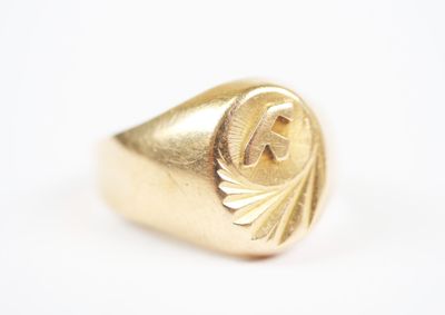 a close up of a gold signet ring on a white surface