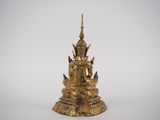 a gold statue of a buddha sitting on top of a pedestal