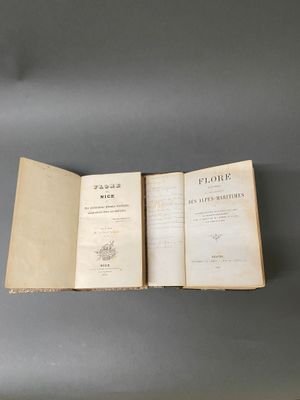 un livre ouvert posé sur une table, elle-même posée sur une autre table
