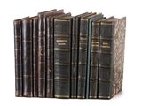 plusieurs vieux livres sont alignés sur une surface blanche