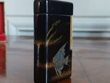 a black and gold cigarette case sitting on a wooden table