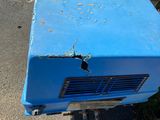 a blue refrigerator sitting on the side of the road