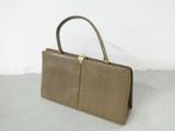 brown leather handbag with gold handles on a white surface