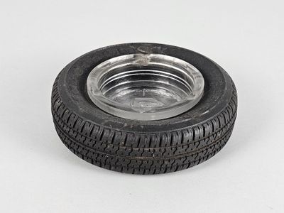 une image montrant un gros plan d'un pneu posé sur une surface blanche