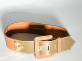 une ceinture munie d'une boucle, posée sur une surface blanche