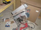 a picture of a cluttered room with a saw on the floor