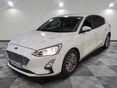 La Ford Focus blanche est garée dans une pièce dont le sol est en damier.