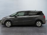 the grey minivan is parked in a room with a gray floor