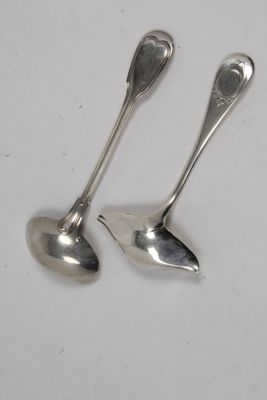 une paire de cuillères en argent posées sur une surface blanche