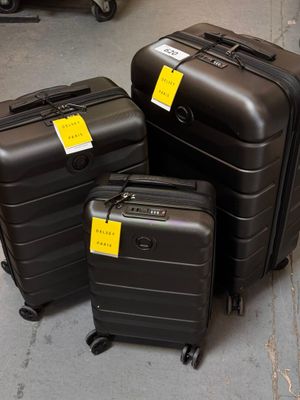 trois bagages posés par terre, munis d'étiquettes