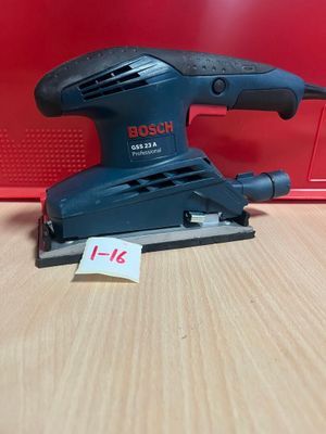 une ponceuse orbitale Bosch posée sur une table en bois, avec une étiquette de prix