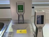 un thermomètre numérique posé sur un plan de travail, à côté d'une boîte