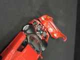 a red toy car that is sitting on a black surface