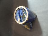 a blue vase with a gold rim sitting on a table